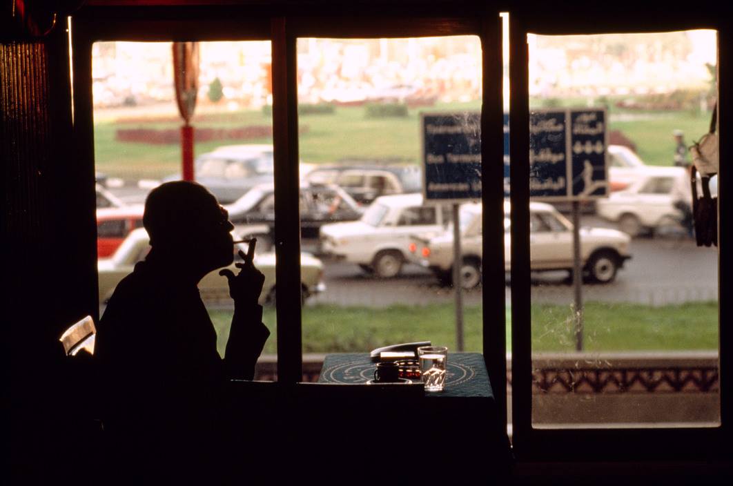 صورة لنجيب محفوظ خلال جلسته في مقهى على بابا ناظرا إلى ميدان التحرير