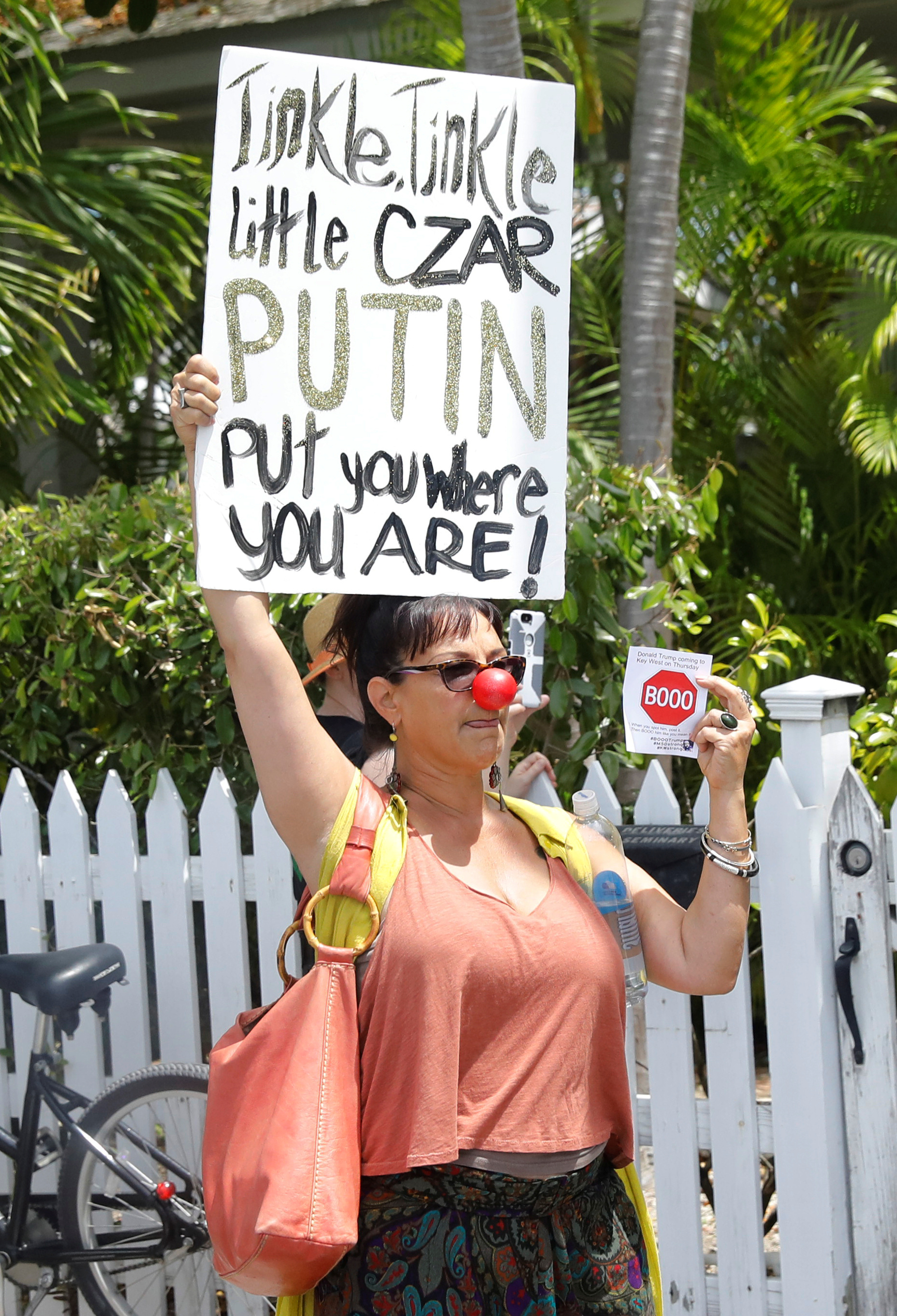 متظاهرة تحمل لافتة مناوئة لترامب