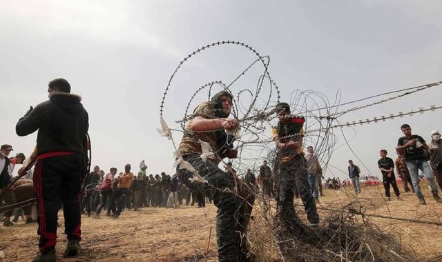 الفلسطينيون يعبربون السياج الفاصل بين غزة واسرائيل