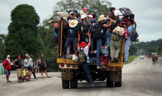 المهاجرون يتسلقون شاحنة
