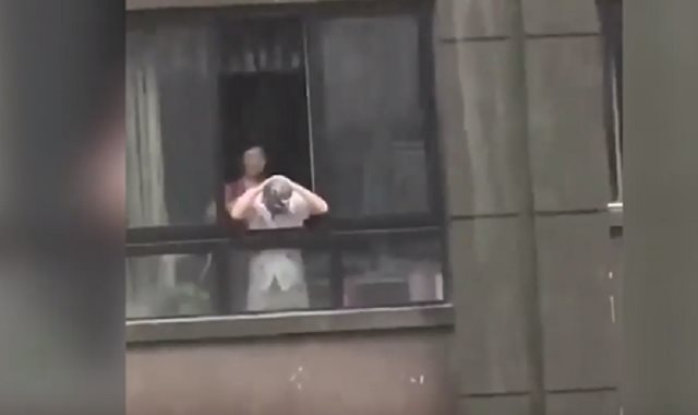  رجل يغسل شعره بمياه الأمطار