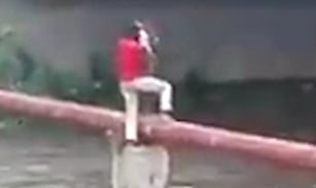 شاهد كيف أنقذ رجل طفل علق أعلى نهر هائج