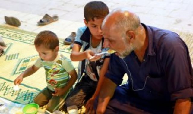 طفل عراقى يطعم أباه