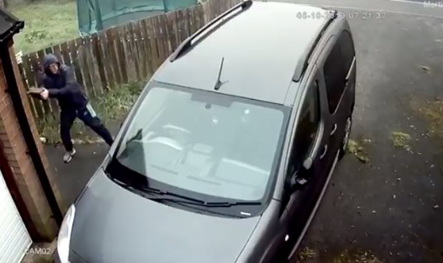 لص يحاول كسر نافذه سيارة