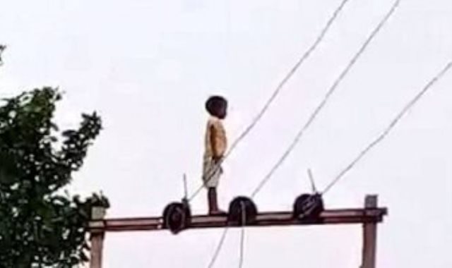 الصبى فوق أعمدة اكلهرباء
