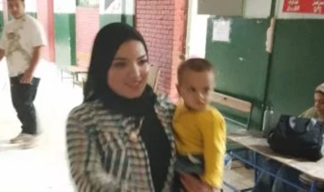 امرأة تحمل طفلها خلال مشاركتها الانتخابية