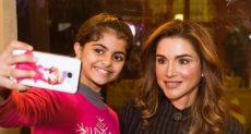 الملكة رانيا مع إحدى الأطفال