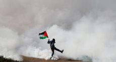 علم فلسطين وسط غاز الاحتلال